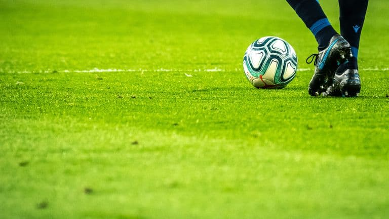 A soccer ball positioned on vibrant grass, indicating a game in progress.