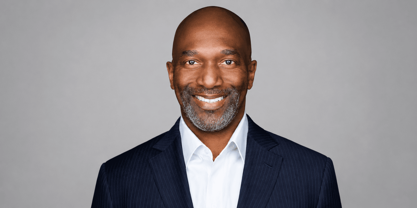 Smiling man in a suit with a gray background