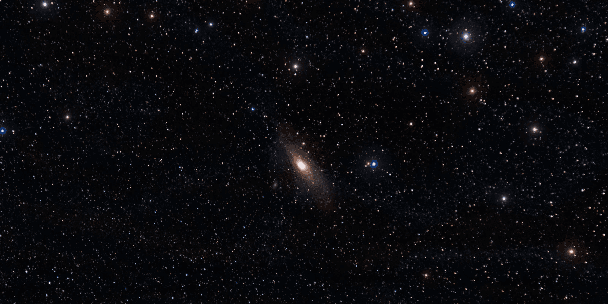 A vast starry sky featuring the Andromeda galaxy and numerous other stars