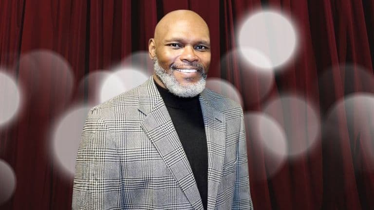 Dr. Michael Anthony Ingram, founder of Quintessential Poetry Network, poses in a formal suit, embodying empathy and healing through poetry.