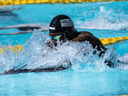 Competitive swimmer wearing a USA swim cap races in a pool during a championship event.