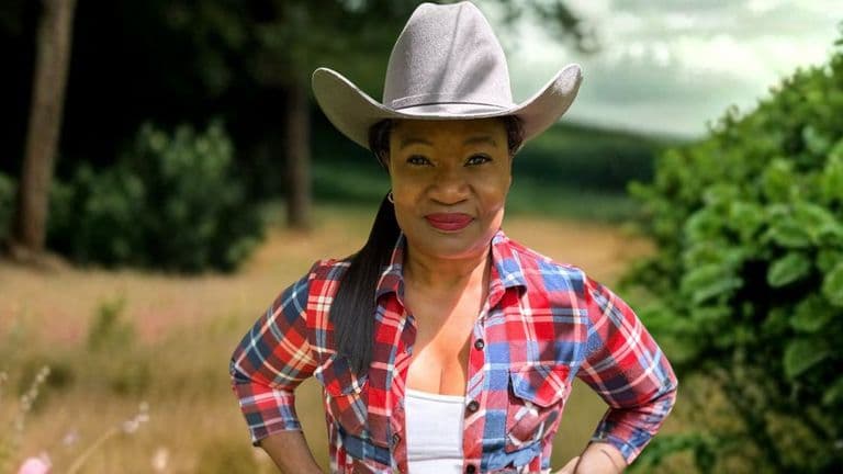 Antoinette Lee, a U.S. Army veteran and wellness advocate, poses outdoors in a plaid shirt and cowboy hat.