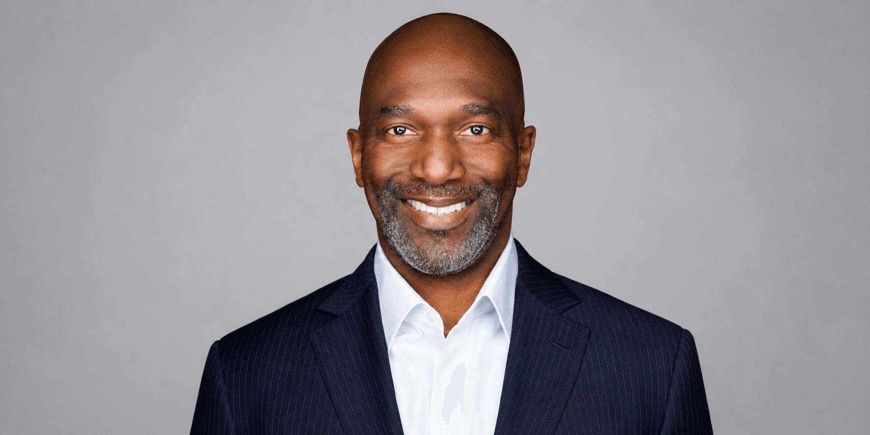 Smiling man in a suit with a gray background
