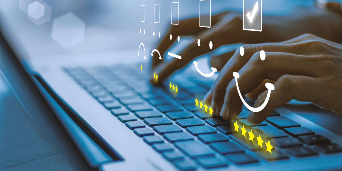 Hands typing on a laptop keyboard with smiley faces and stars graphic overlay