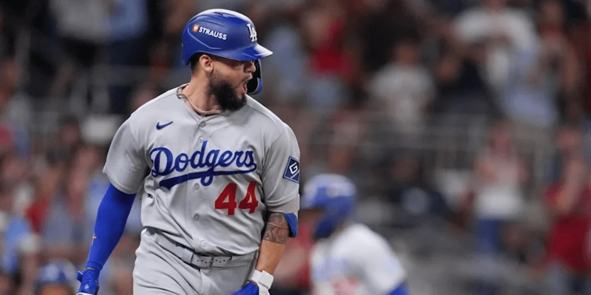 Baseball player celebrating a hit while wearing a Dodgers jersey and helmet