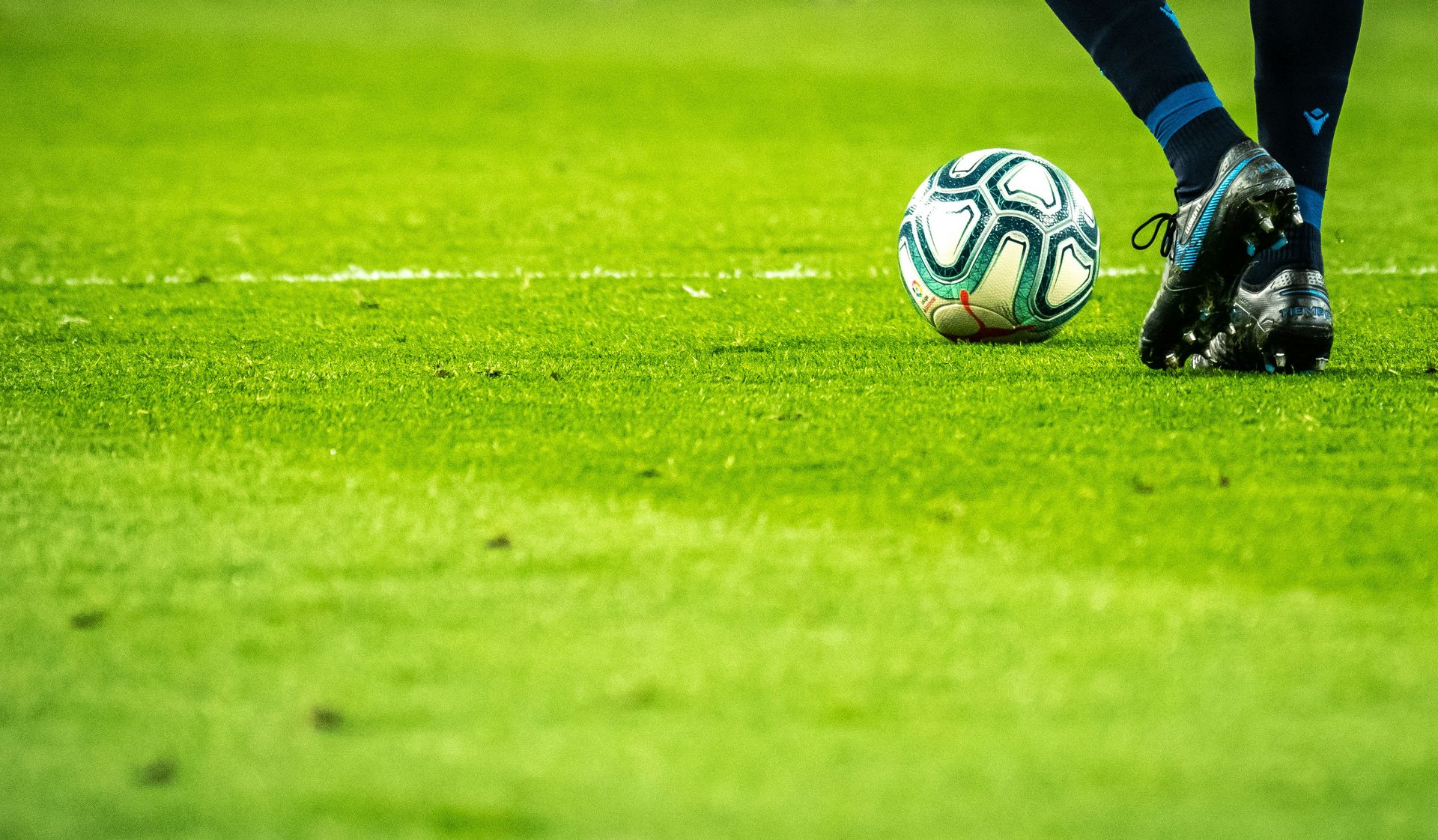 A soccer ball positioned on vibrant grass, indicating a game in progress.