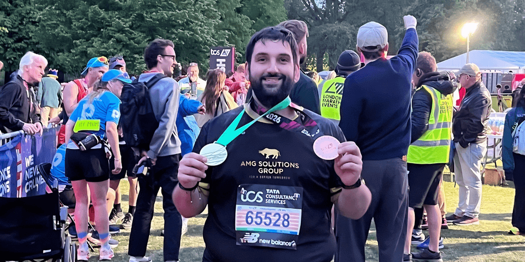 Man proudly displays medal after completing the 2026 TCS London Marathon.