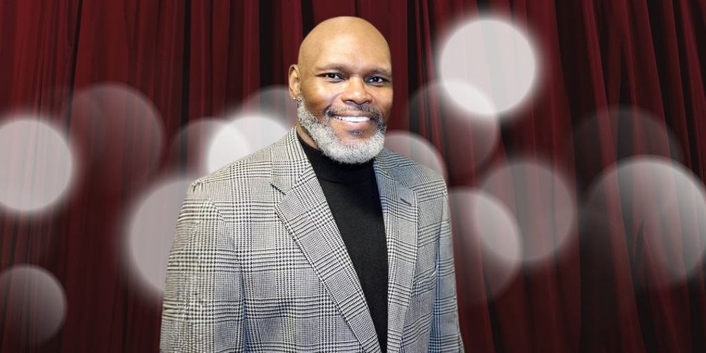 Dr. Michael Anthony Ingram, founder of Quintessential Poetry Network, poses in a formal suit, embodying empathy and healing through poetry.