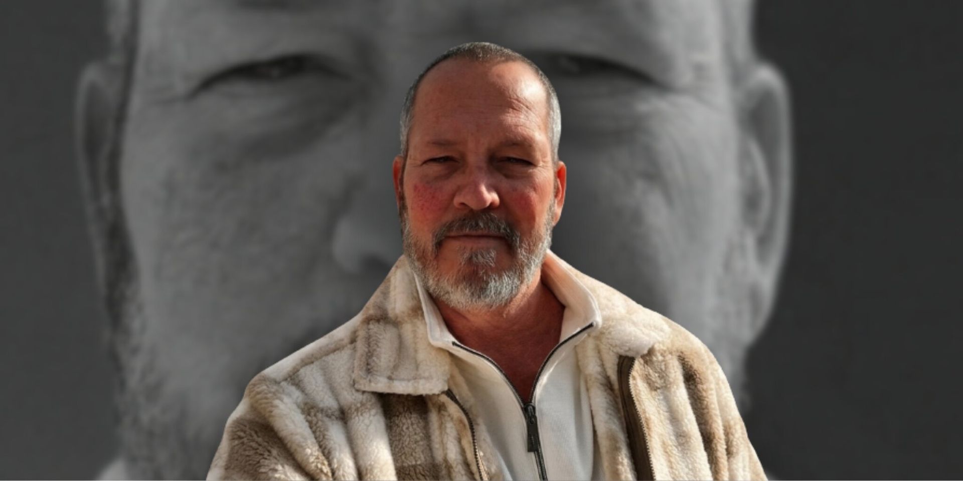 Portrait of a bearded man in front of a large grayscale face backdrop.