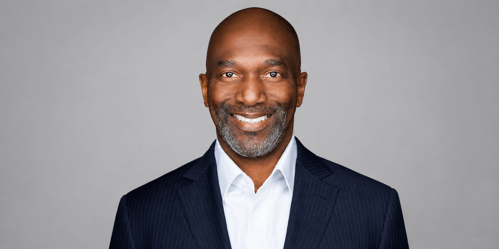 Smiling man in a suit with a gray background