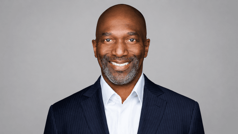 Smiling man in a suit with a gray background
