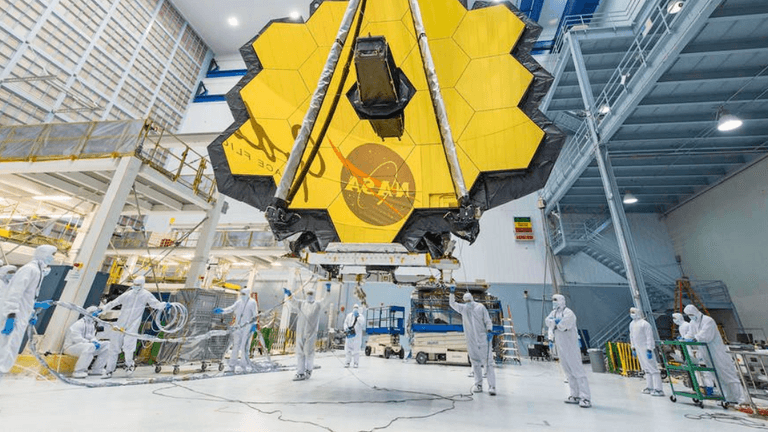 NASA technicians working on the large, hexagonal, gold-coated James Webb Space Telescope