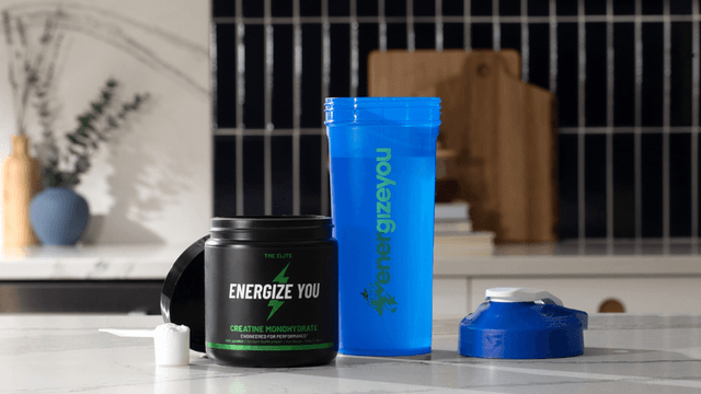 Fitness products including a shaker cup and energy supplement container on a kitchen counter