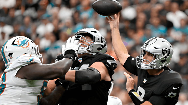 Football players in action during an NFL game, one throwing a pass under pressure