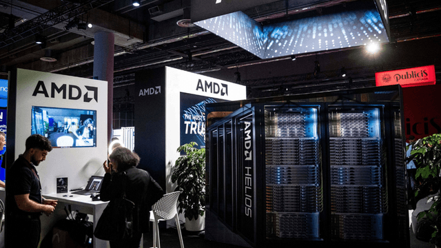 AMD booth at tech event featuring displays, servers, and attendees engaging with technology