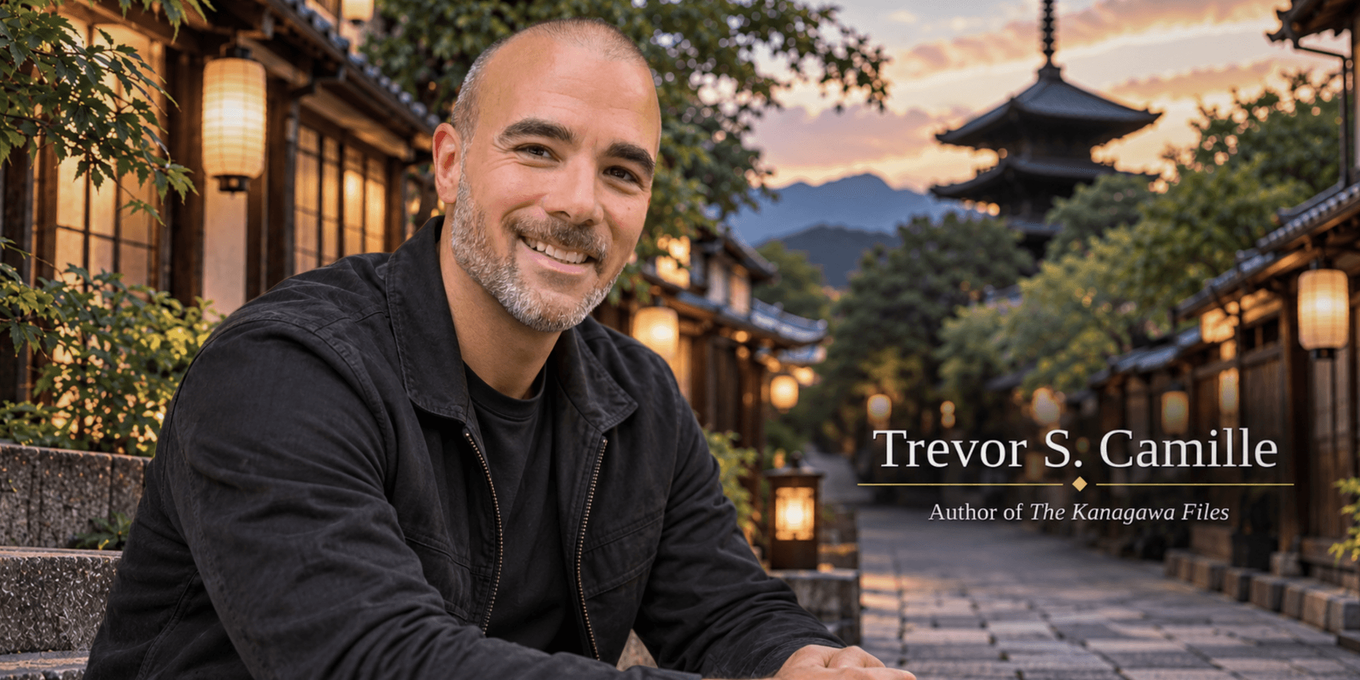 Smiling man in a black jacket sitting outdoors in a picturesque setting at dusk