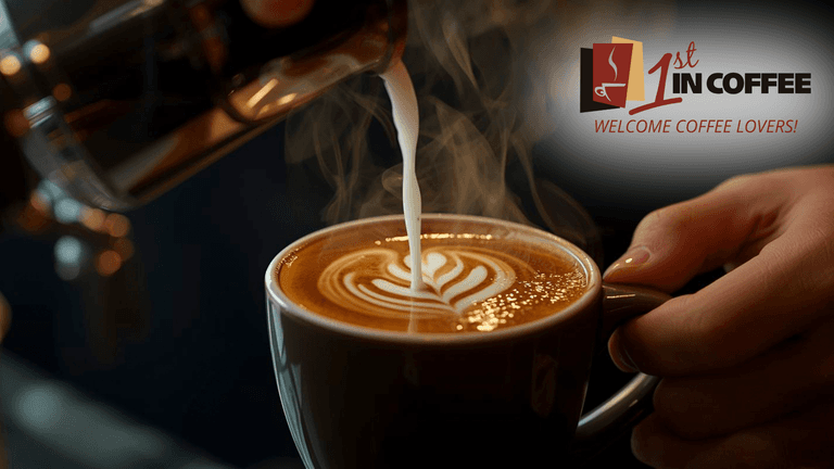 Coffee being poured with frothy milk creating a leaf design in a cup