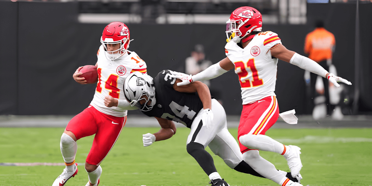Football players in action during a game, one evading a tackle from two opponents