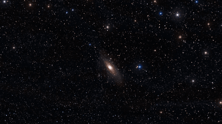 A vast starry sky featuring the Andromeda galaxy and numerous other stars