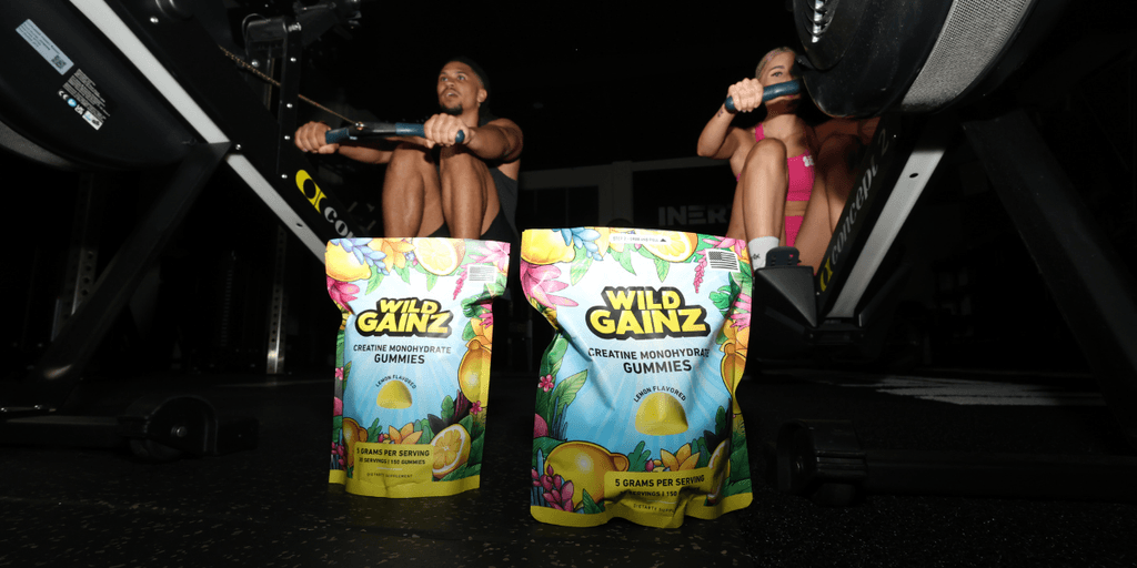 Wild Gainz creatine gummies displayed in a gym setting with athletes using rowing machines.