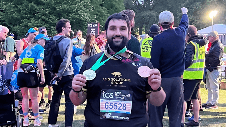 Man proudly displays medal after completing the 2026 TCS London Marathon.