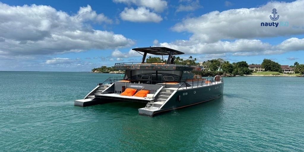 Modern catamaran floating on calm coastal waters beneath a partly cloudy sky.