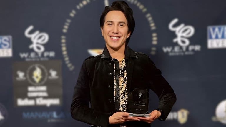 Ricky Rebel proudly holding his American Entertainment Hall of Fame award at Warner Brothers Studios, celebrating his groundbreaking artistry.