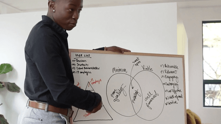 A Training Booker instructor engages with a whiteboard, illustrating the platform’s blend of human connection and measurable learning outcomes.