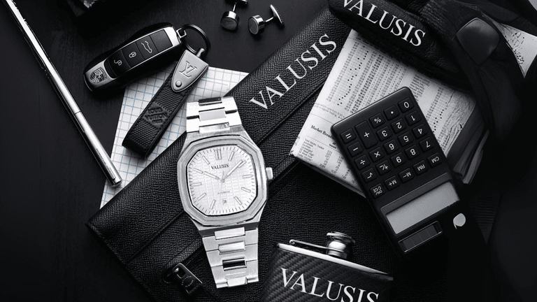 An image featuring a luxury setup with a Valusis watch placed alongside premium items like a Porsche key, Louis Vuitton wallet, and a calculator, emphasizing sophistication and elegance.