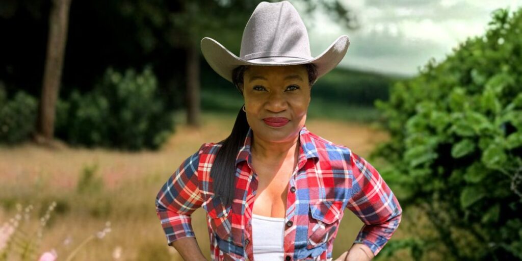 Antoinette Lee, a U.S. Army veteran and wellness advocate, poses outdoors in a plaid shirt and cowboy hat.