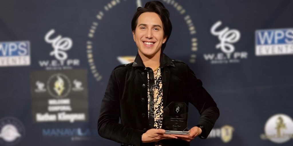 Ricky Rebel proudly holding his American Entertainment Hall of Fame award at Warner Brothers Studios, celebrating his groundbreaking artistry.